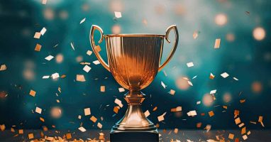 Gold trophy surrounded by falling confetti, representing achievement and success.